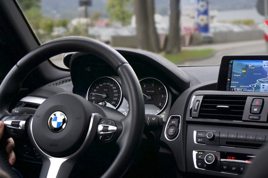 Mechanic professionally diagnosing a Footwell Module (FRM) issue in a BMW vehicle, using an OBD-II scanner, symbolizing the in-depth discussion about FRM symptoms and solutions in the article